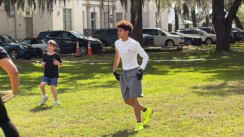Boy playing football outside in Palm Row