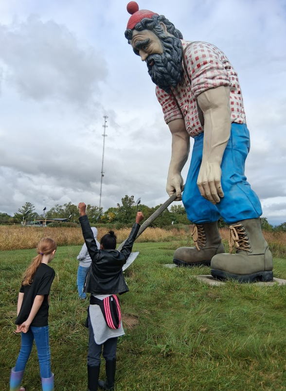 students posing with a Paul Bunyan sculpture