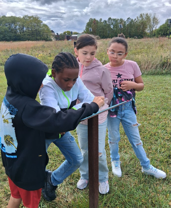 students reading info on a sculpture.