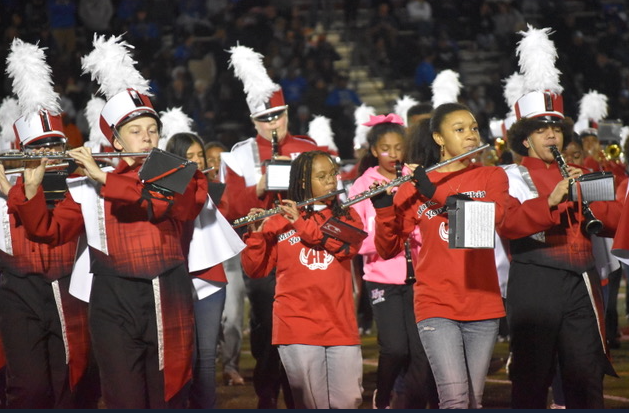 kid playing in the band holding flutes.