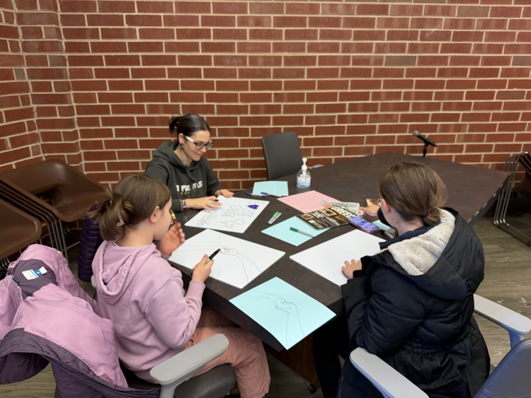 A family sitting at a table creating art together