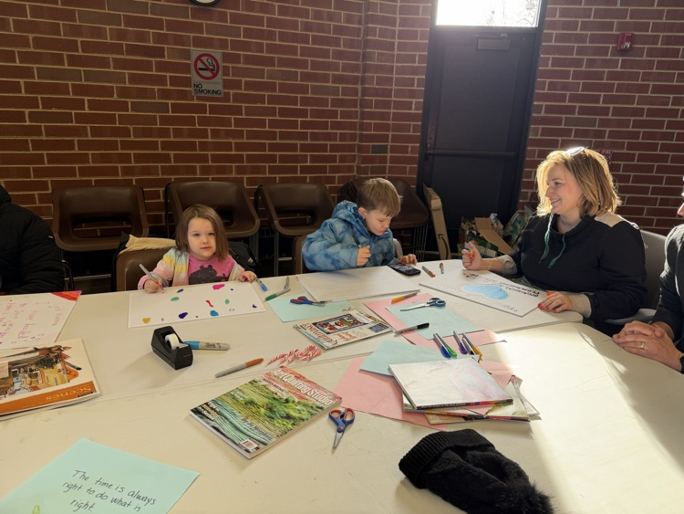 art supplies on a table with a child and mother working on a project