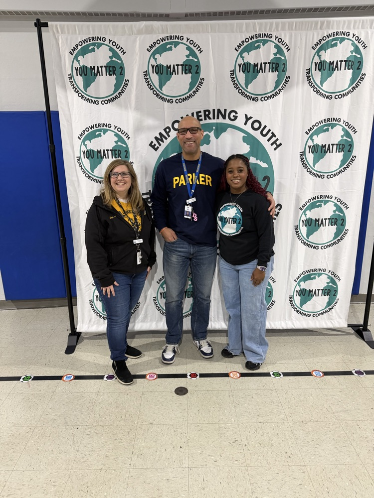 three adults standing in front of a logo backdrop