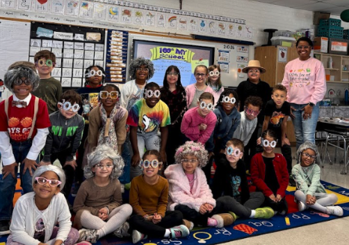 kids wearing 100th day of school glasses and smiling at the camera.