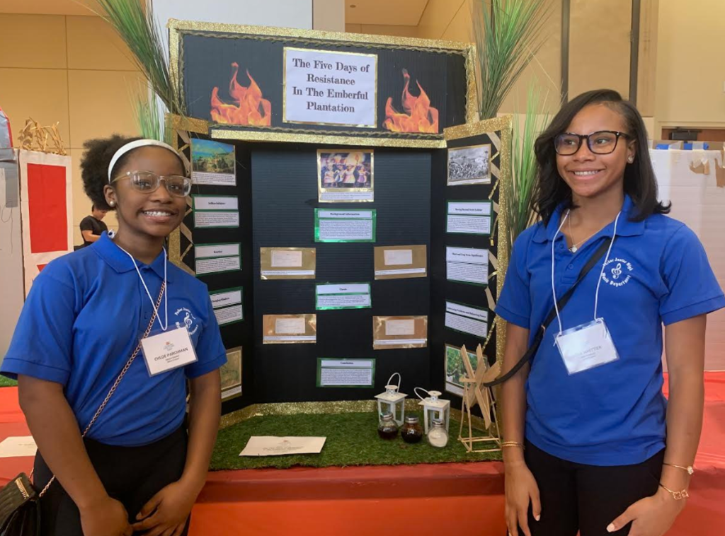 kids standing in front of a project