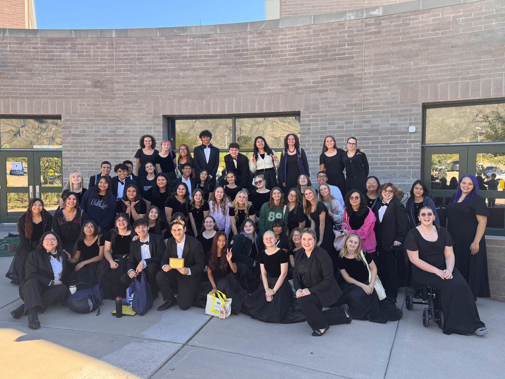 A large group of Flowing Wells High School choir students from Bella Voce and Choralires pose together outside Catalina Foothills High School after the ACE Fall Choral Festival, smiling proudly in their black concert attire.