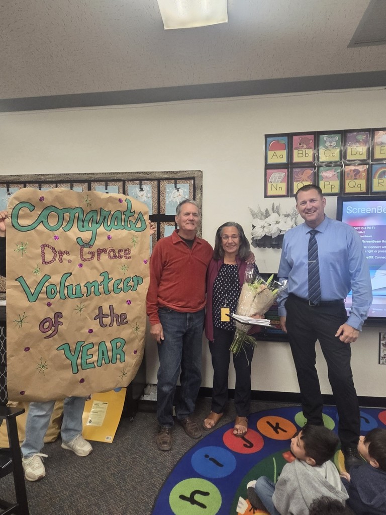 Dr. Grace receiving her Volunteer of the year award with her husband and principal, Alan Schmidt.