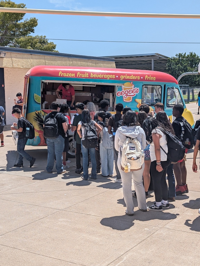 Students stand outside in a line for a cool treat.