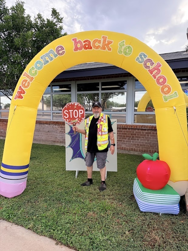 Photo of crossing guard under pencil arch