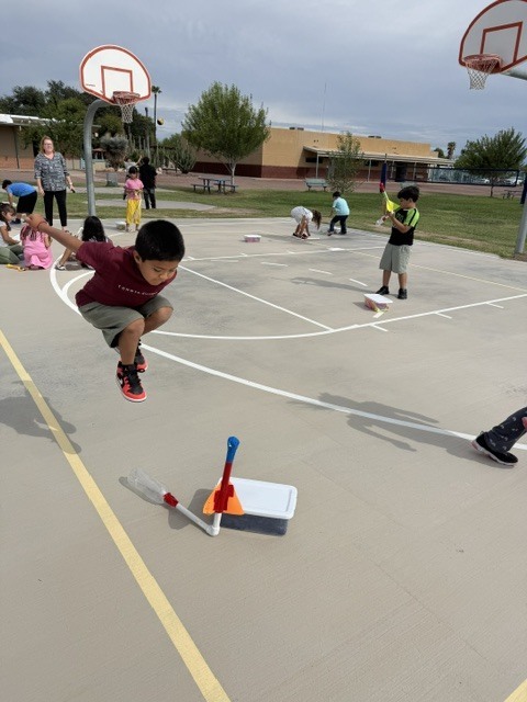 student jumping high to launch his stomp rocket