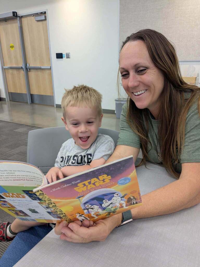 Parent is happily reading to their child at a family event. 