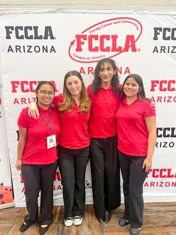 Fashion students stand together in front of an FCCLA backdrop. 