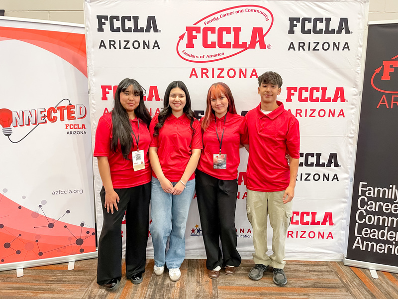 Four Culinary Arts  students stand together in front of an FCCLA backdrop. 