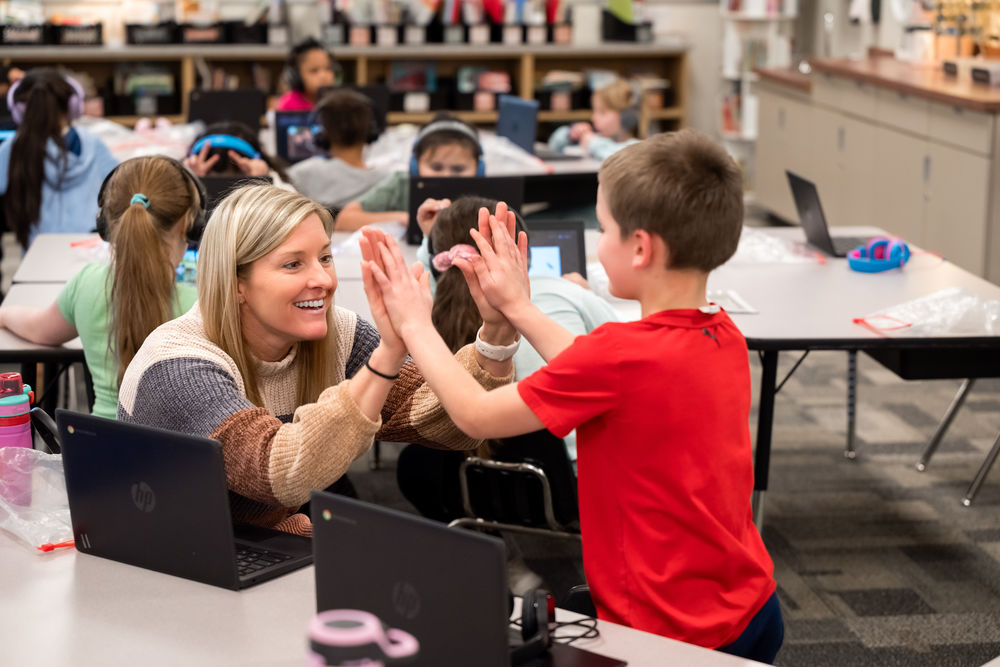 Principal and student celebrating during work time.