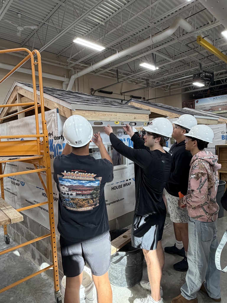 Students leveling roof on construction worksite.