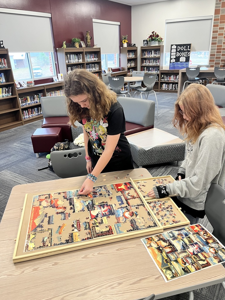 students piecing together a puzzle in the library