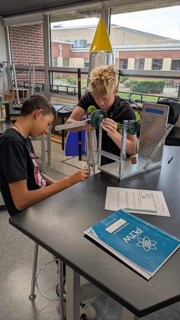 Two students in Principles of Engineering working on a lab about the wheel-axle machine. 