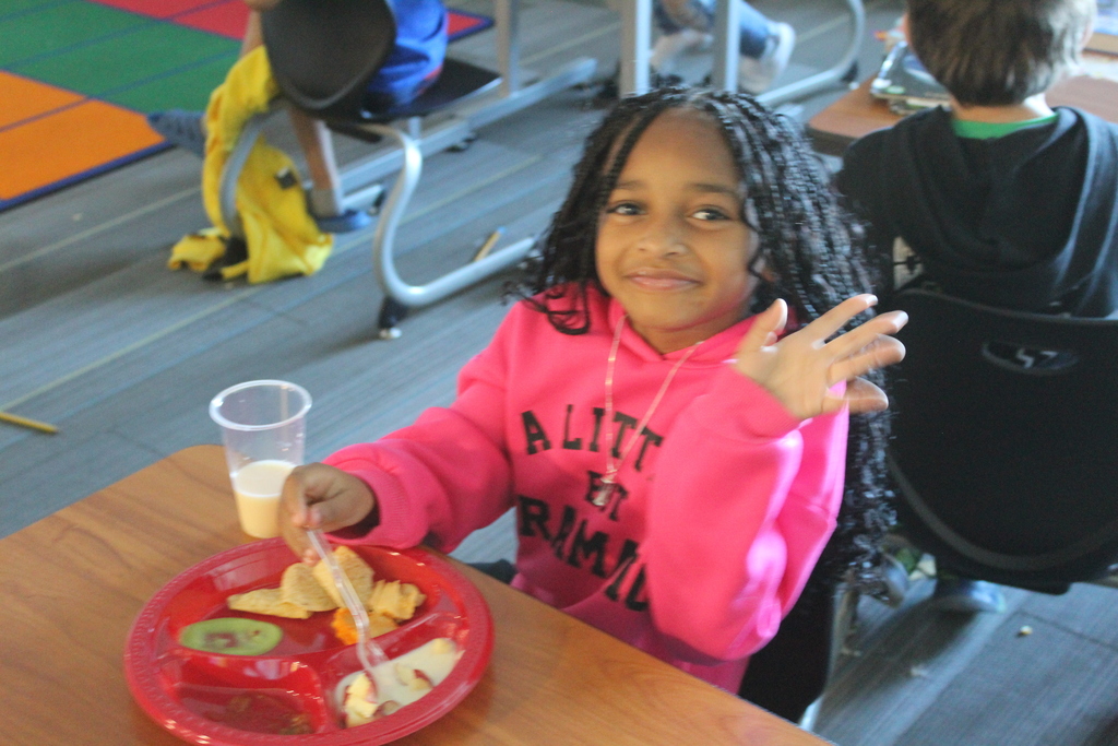 Student smiling at their desk