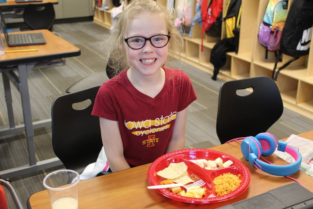 student smiling at her desk