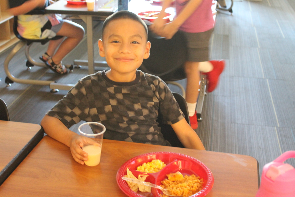 student smiling at their desk
