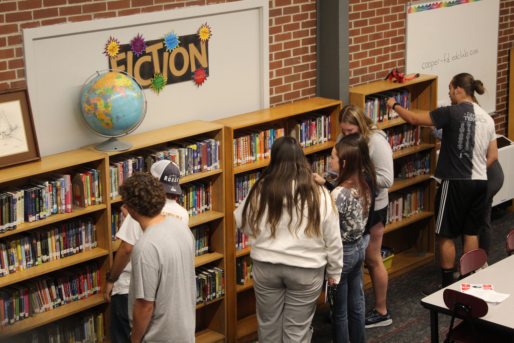 students looking at books in a library