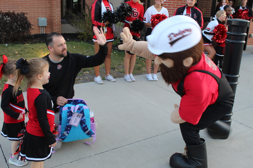 man giving a high five to school mascot