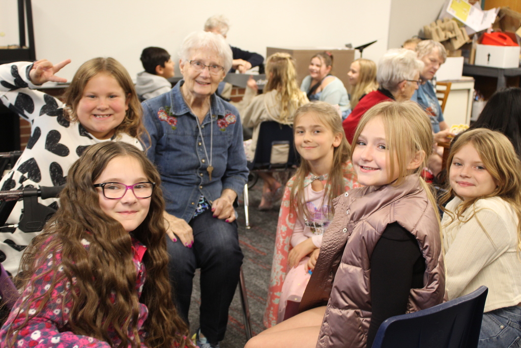 group photo of children smiling with an adult