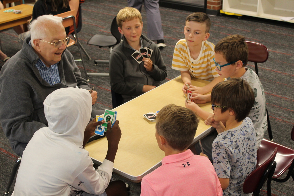 people playing a card game around a table