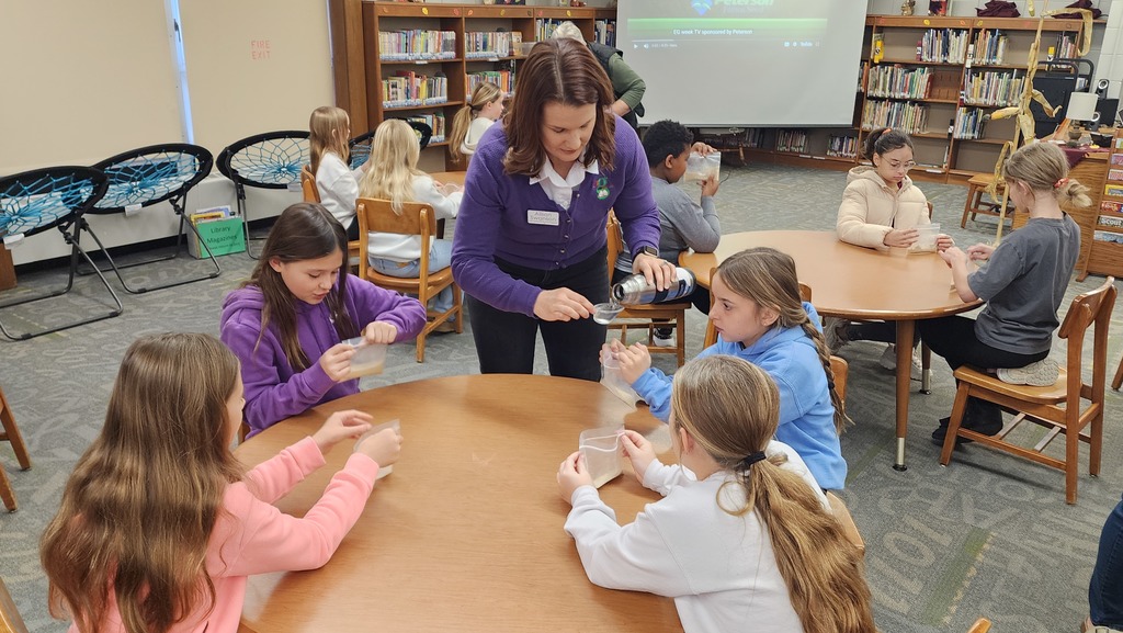 adult helping students with science experiment