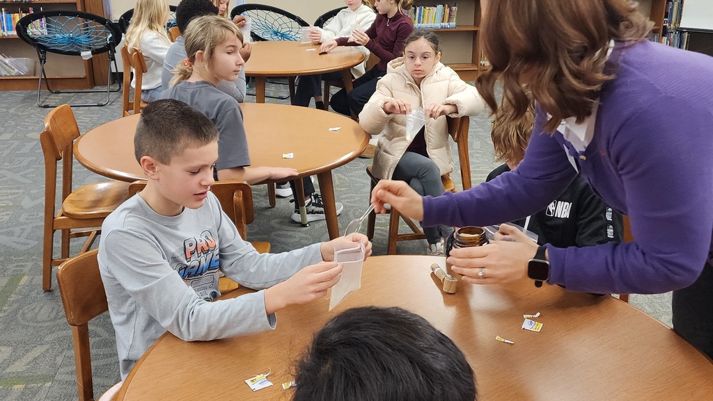 adult helping student with science experiment