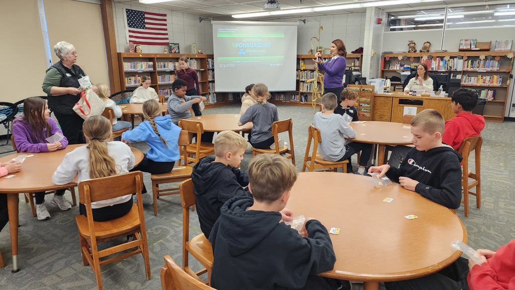 students listening to adult in a library
