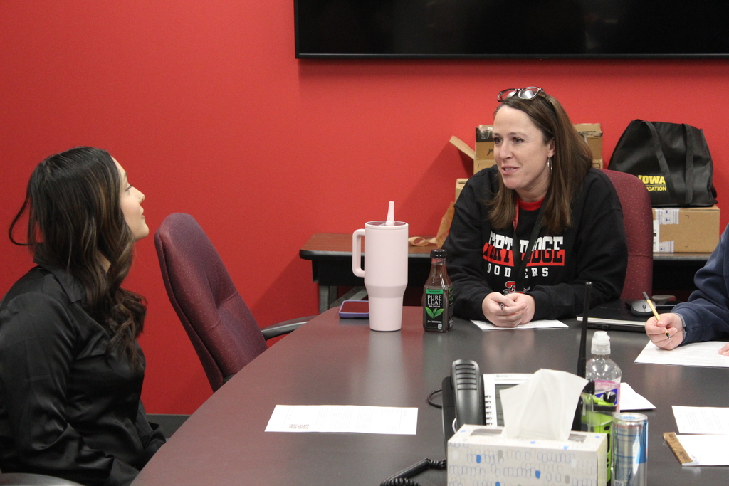 student and adult talking to each other at a table