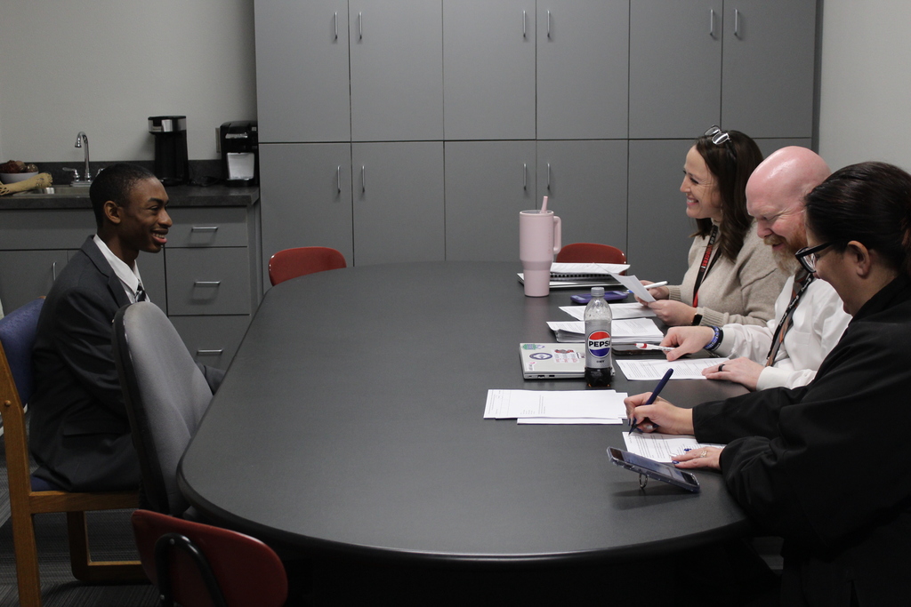 student being interviewed by paned of adults