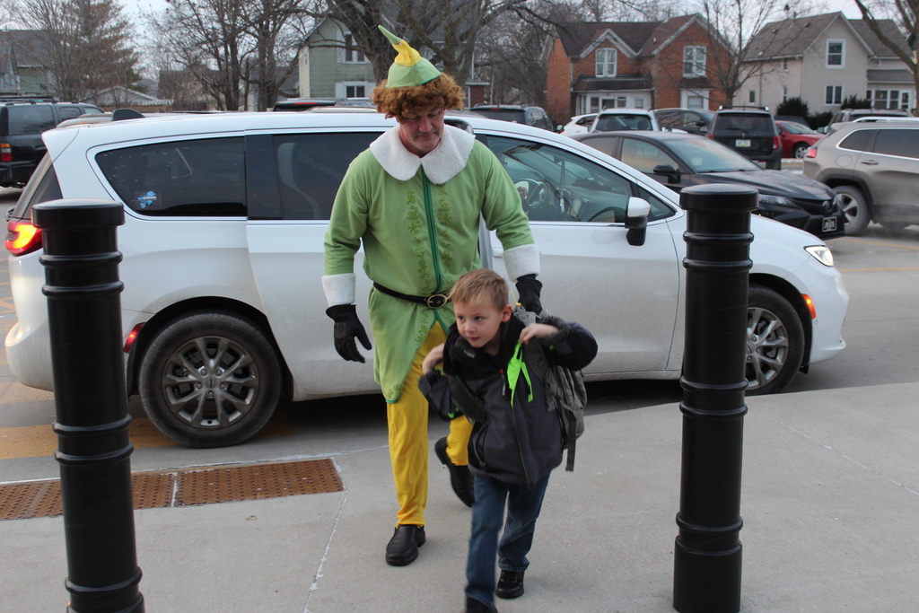 Buddy the Elf walking behind a child