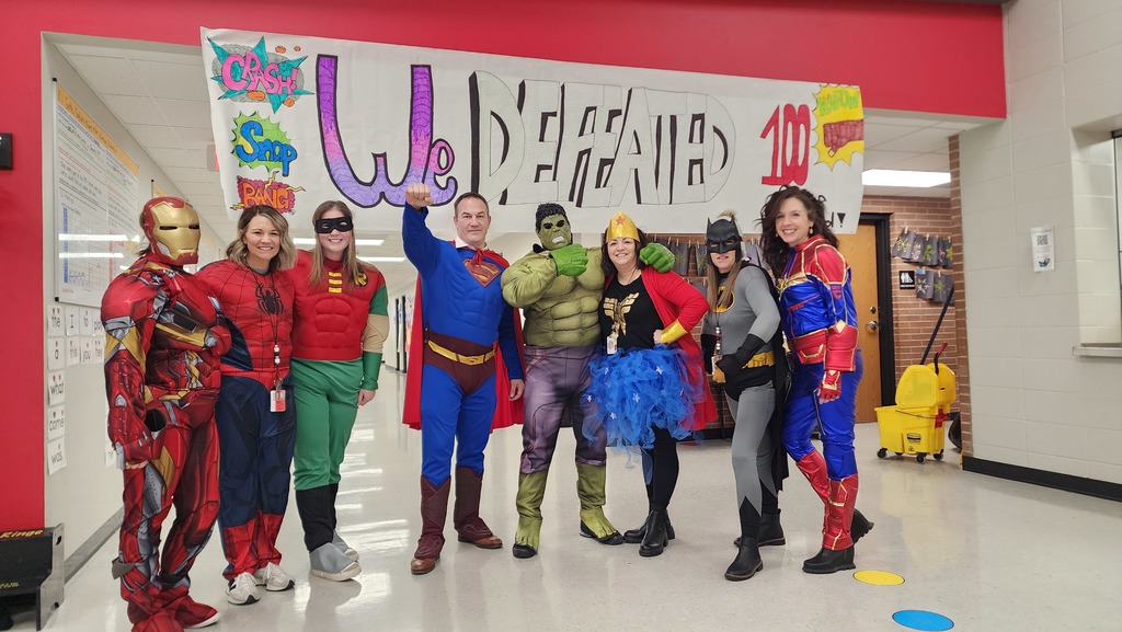 adults dressed as super heroes smiling at the camera