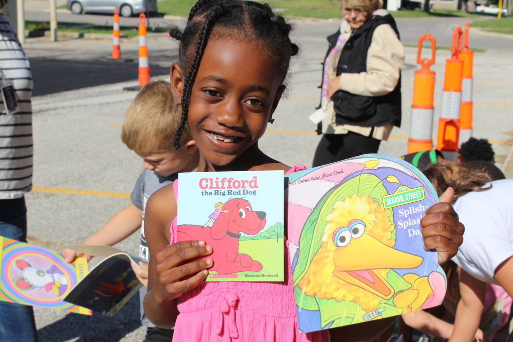 student smiling while holding books