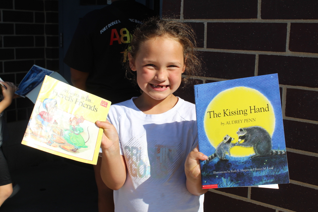 student smiling while holding books