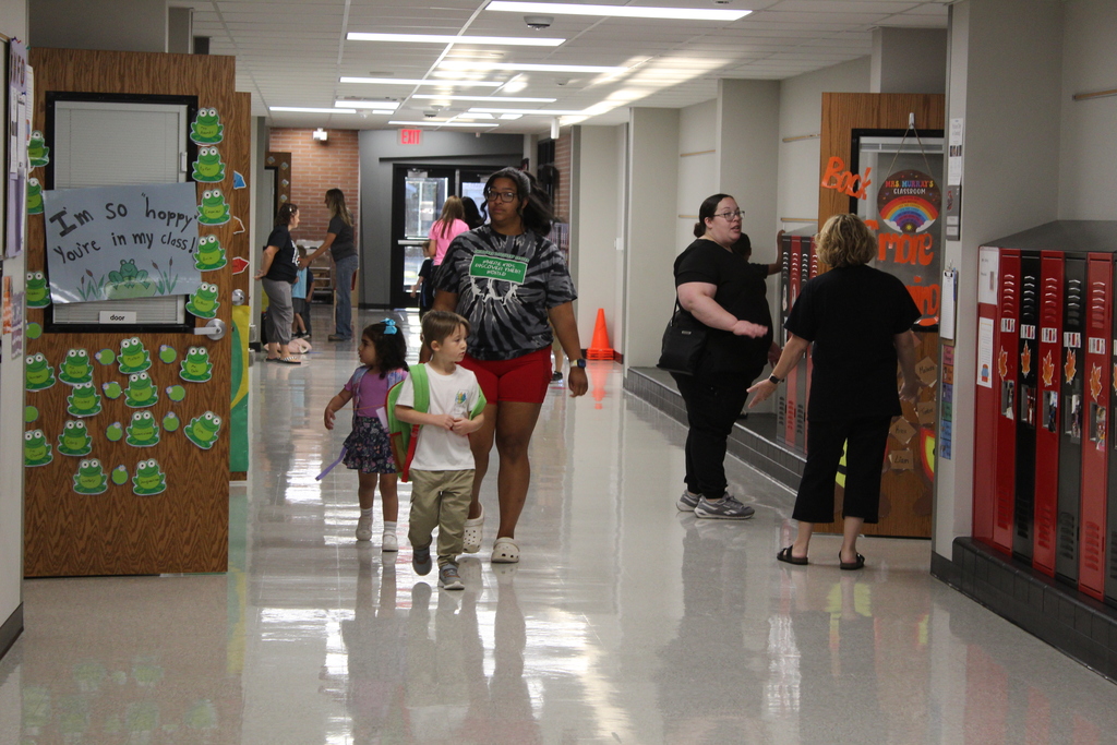 children and adult walking down hallway
