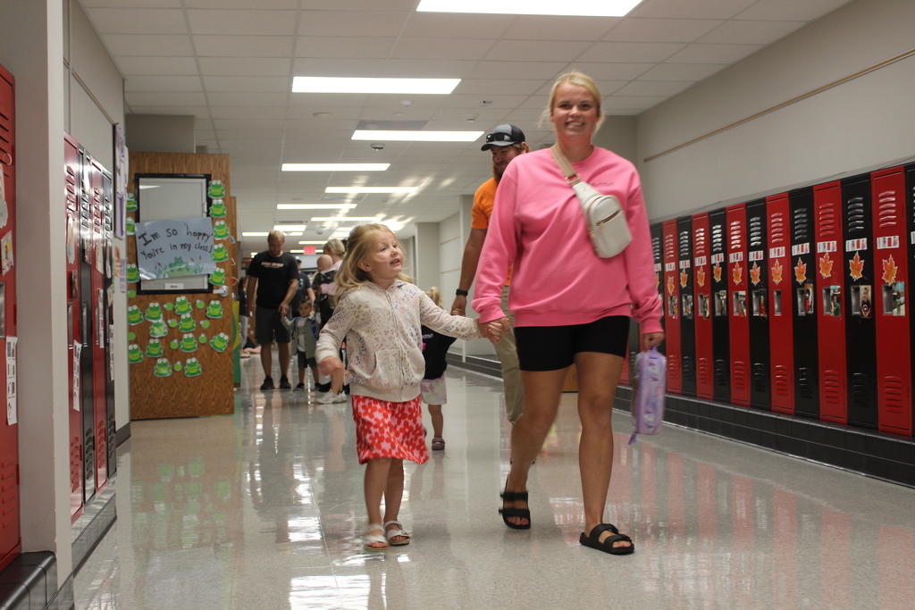parent and child walking down hallway holding hands