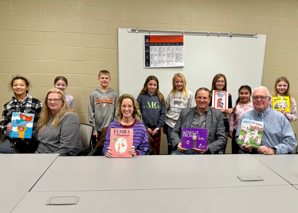 the board members with their books from the students