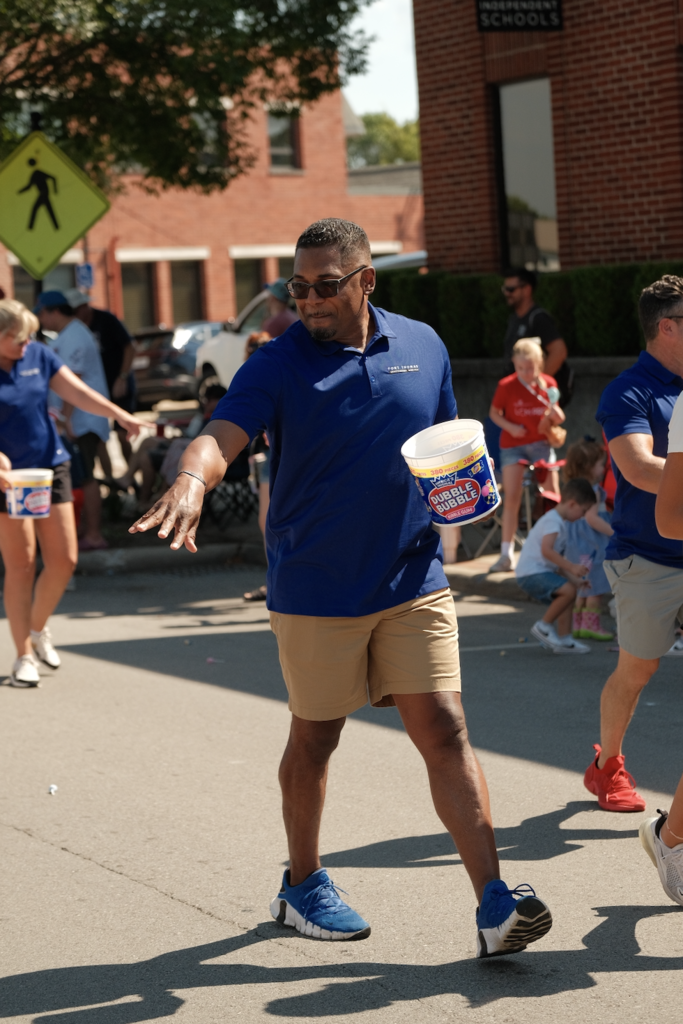 Board of Education member David Russell distributes bubble gum on the parade route.