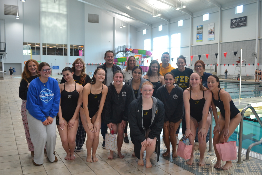 Swim team posing with their selected teachers