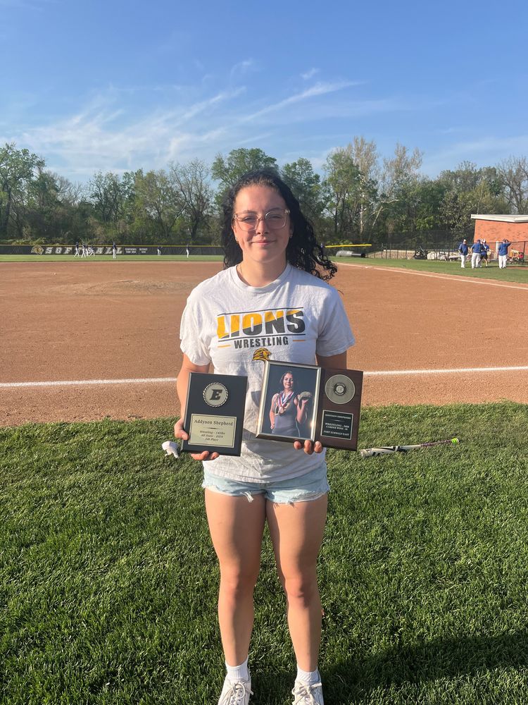 Addyson Shepherd holding her record breaker plaque and all state plaque