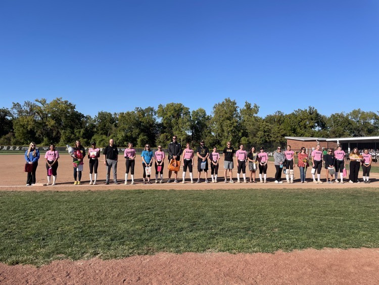 Softball players lined up with their teacher