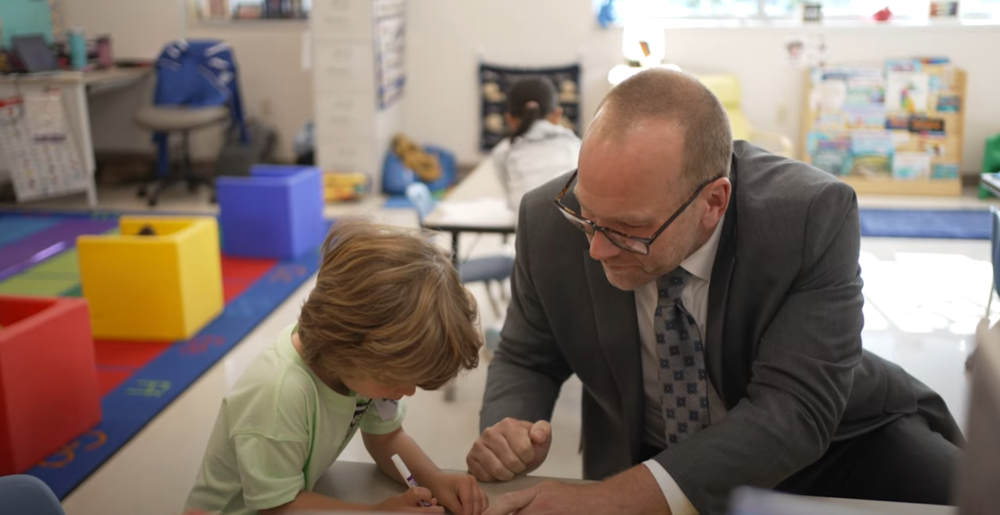 Superintendent helps pre-schooler practice writing name