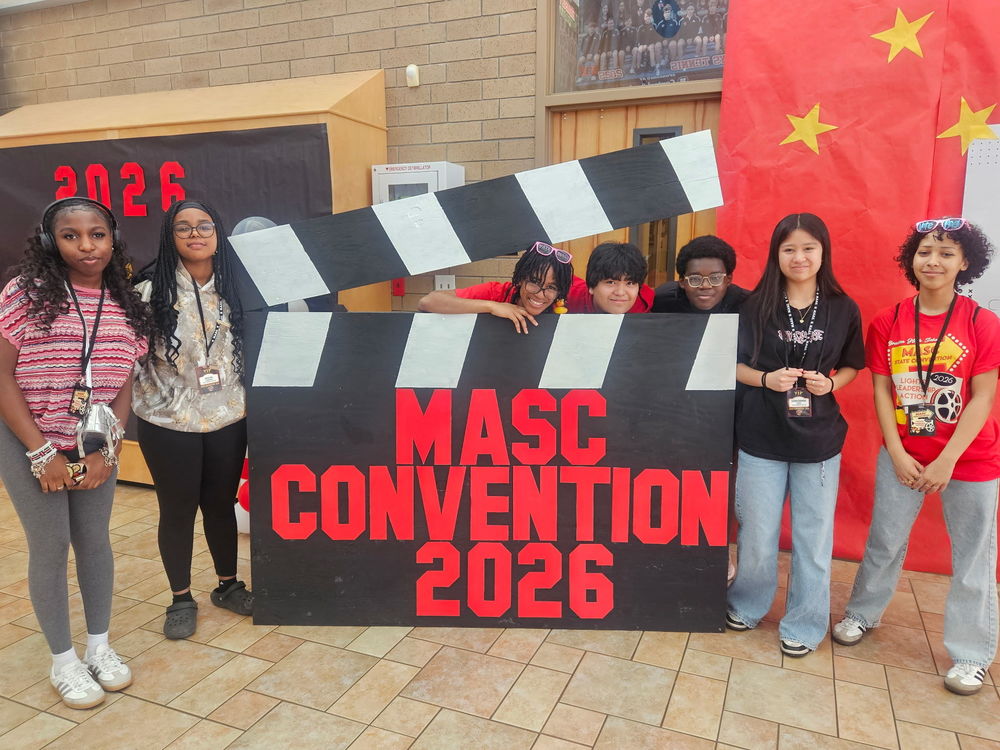 Student council members posing with a large film strip at the MASC convention