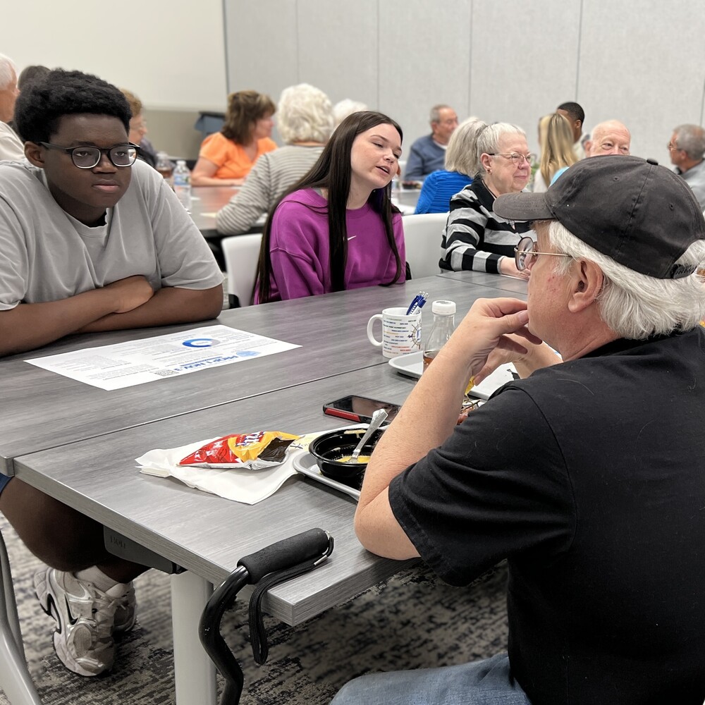 Two FZE Students sitting with our residents and discussing Fort Zumwalt related information
