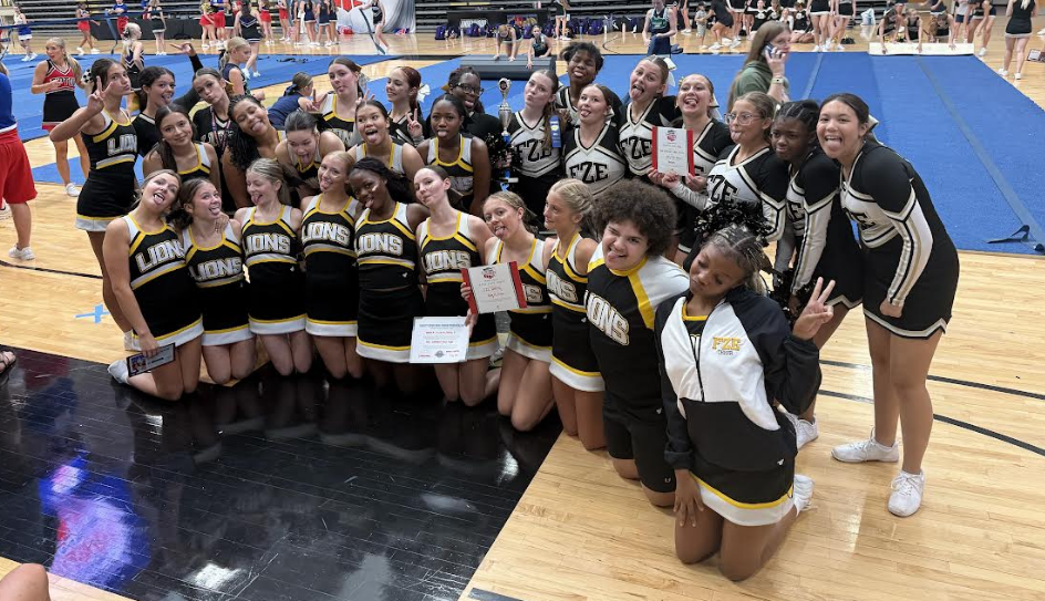 Cheer team posing on the floor together at camp