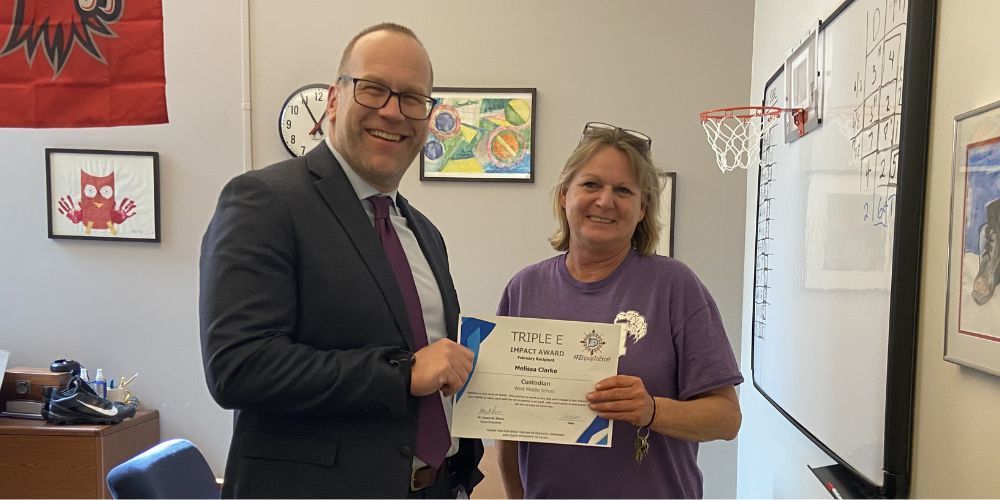 Superintendent and Triple E winner hold up certificate