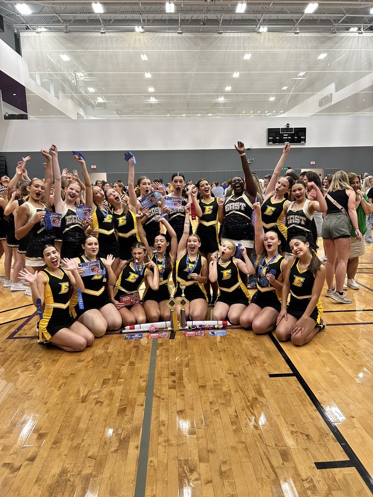 The dance program posing with their hardware from camp